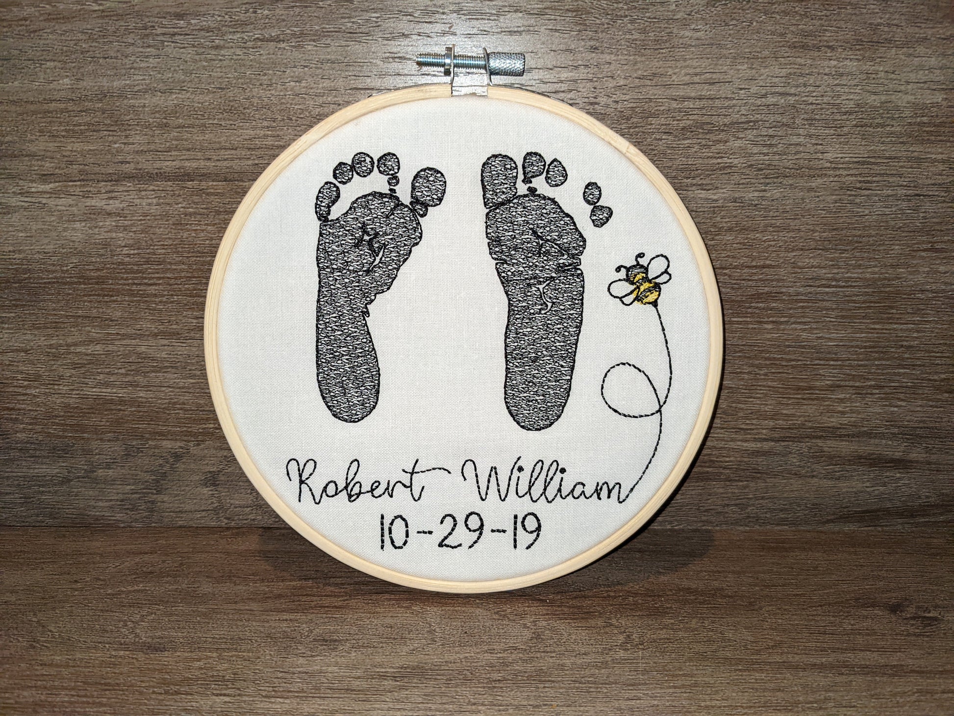 Embroidered baby feet with bee design