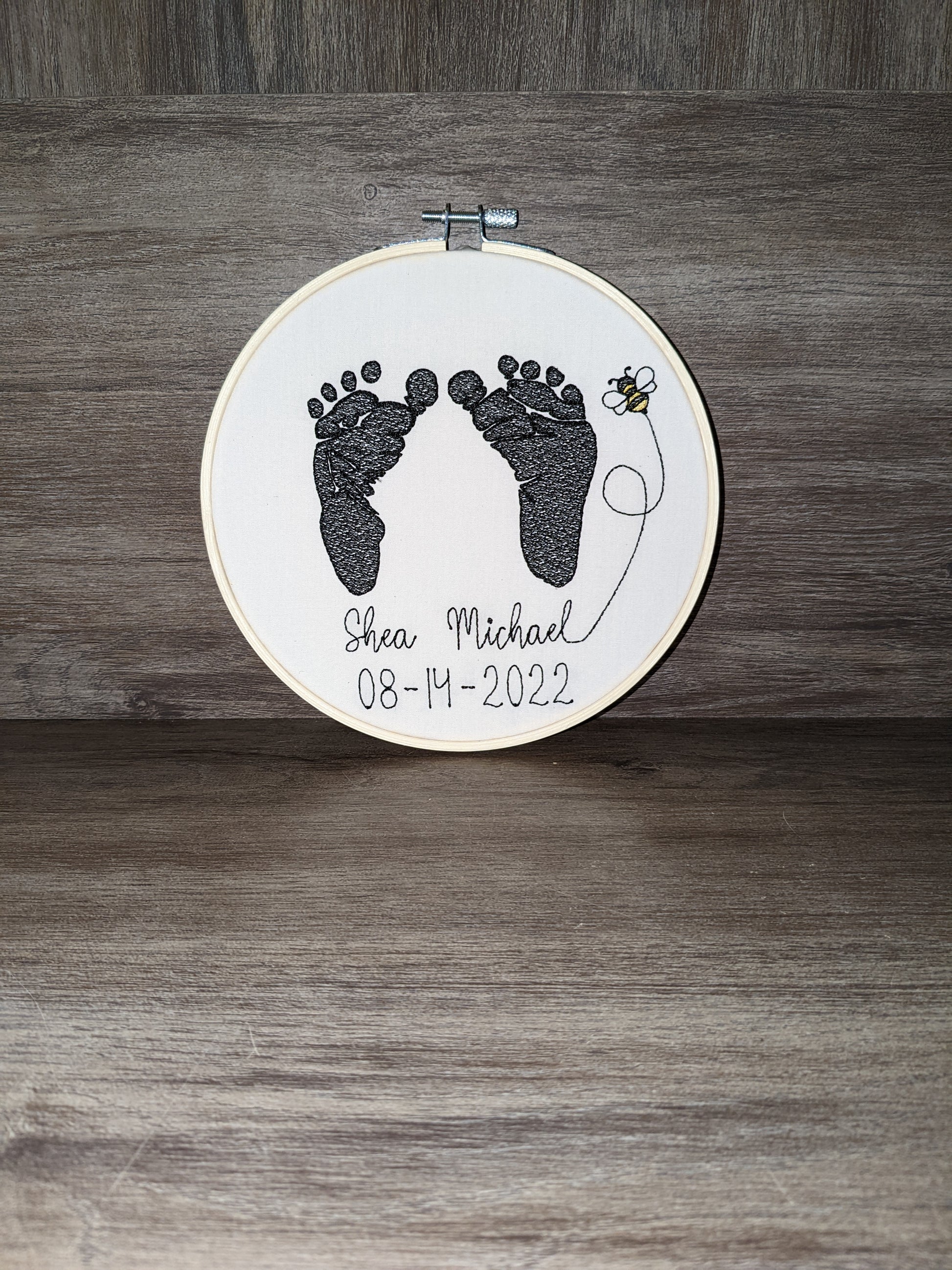 Embroidered baby feet with bee design