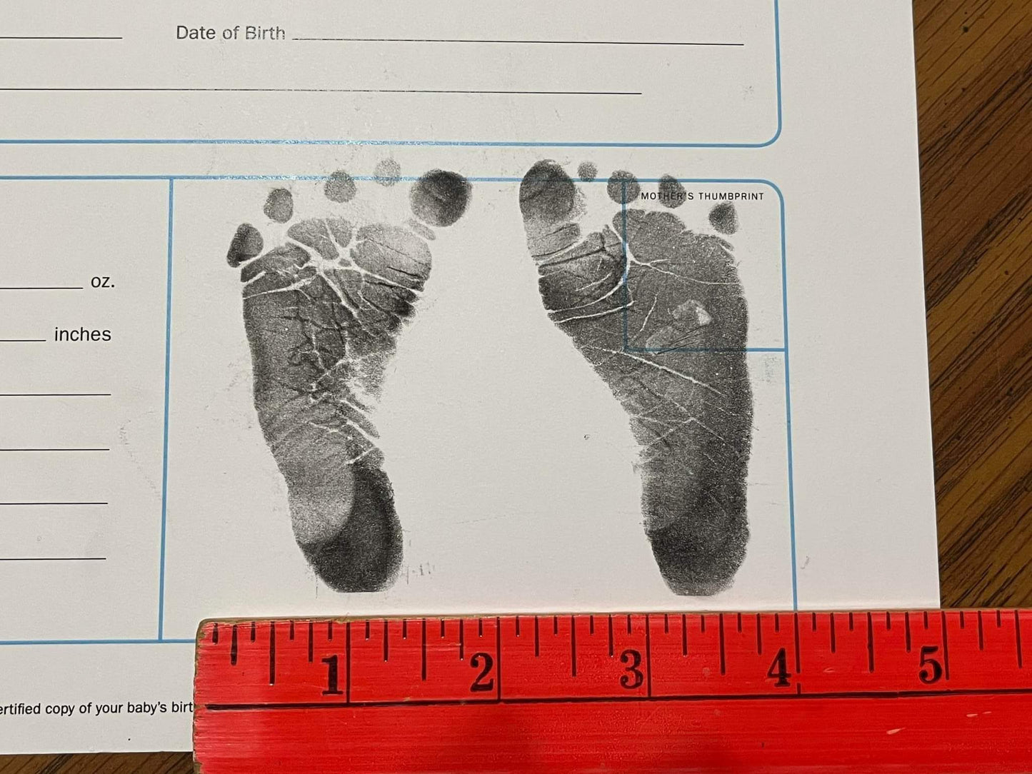 Example of baby feet inked at birth with ruler for size