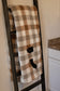 Two states appliqued on a plaid blanket connected by hearts over cities