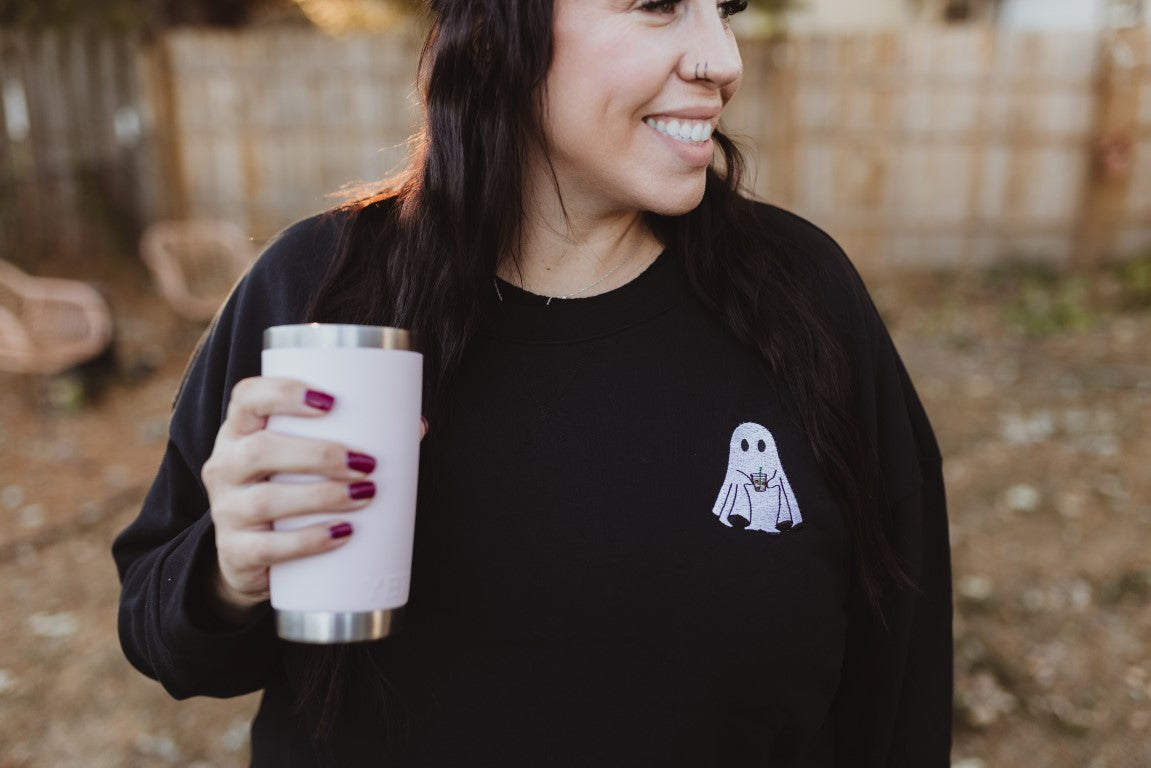 woman holding coffee cup for iced coffee ghost sweatshirt