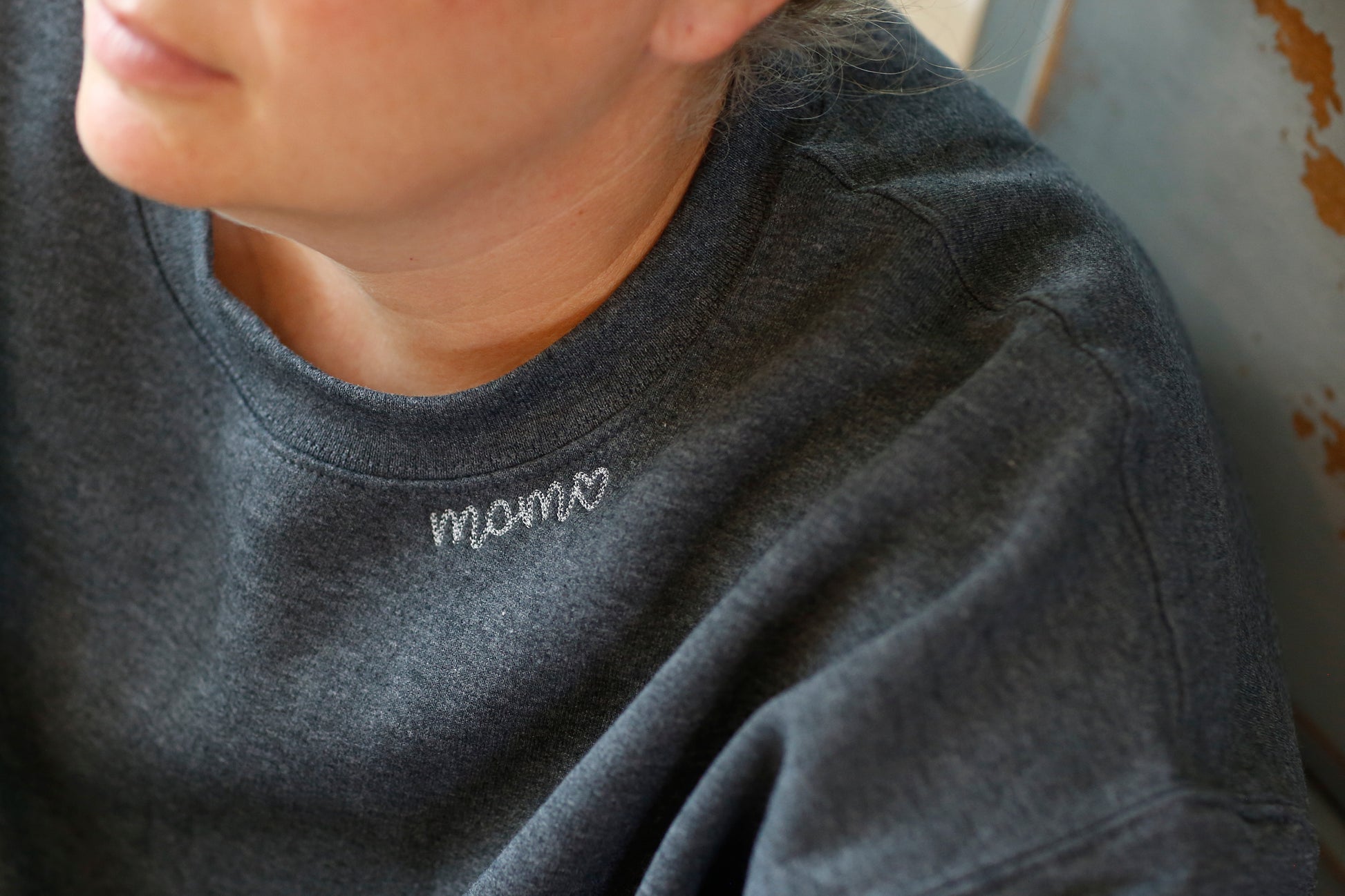 Mama collar embroidered along the neckline of a heather crewneck sweatshirt