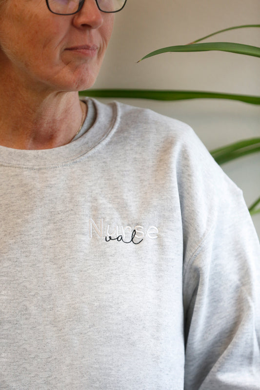 Personalized Nurse sweatshirt with a name embroidered in cursive on the chest