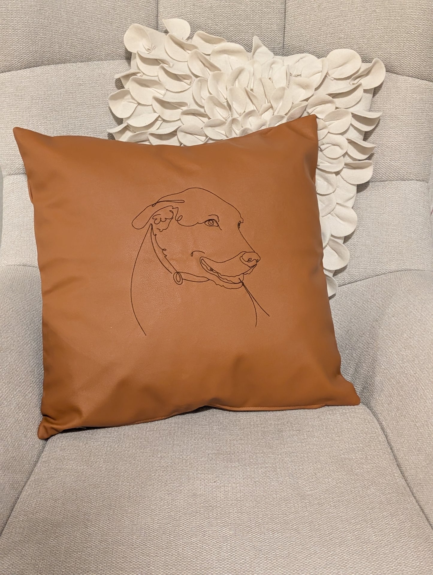 Embroidered pet line art faux leather pillow cover on an accent chair